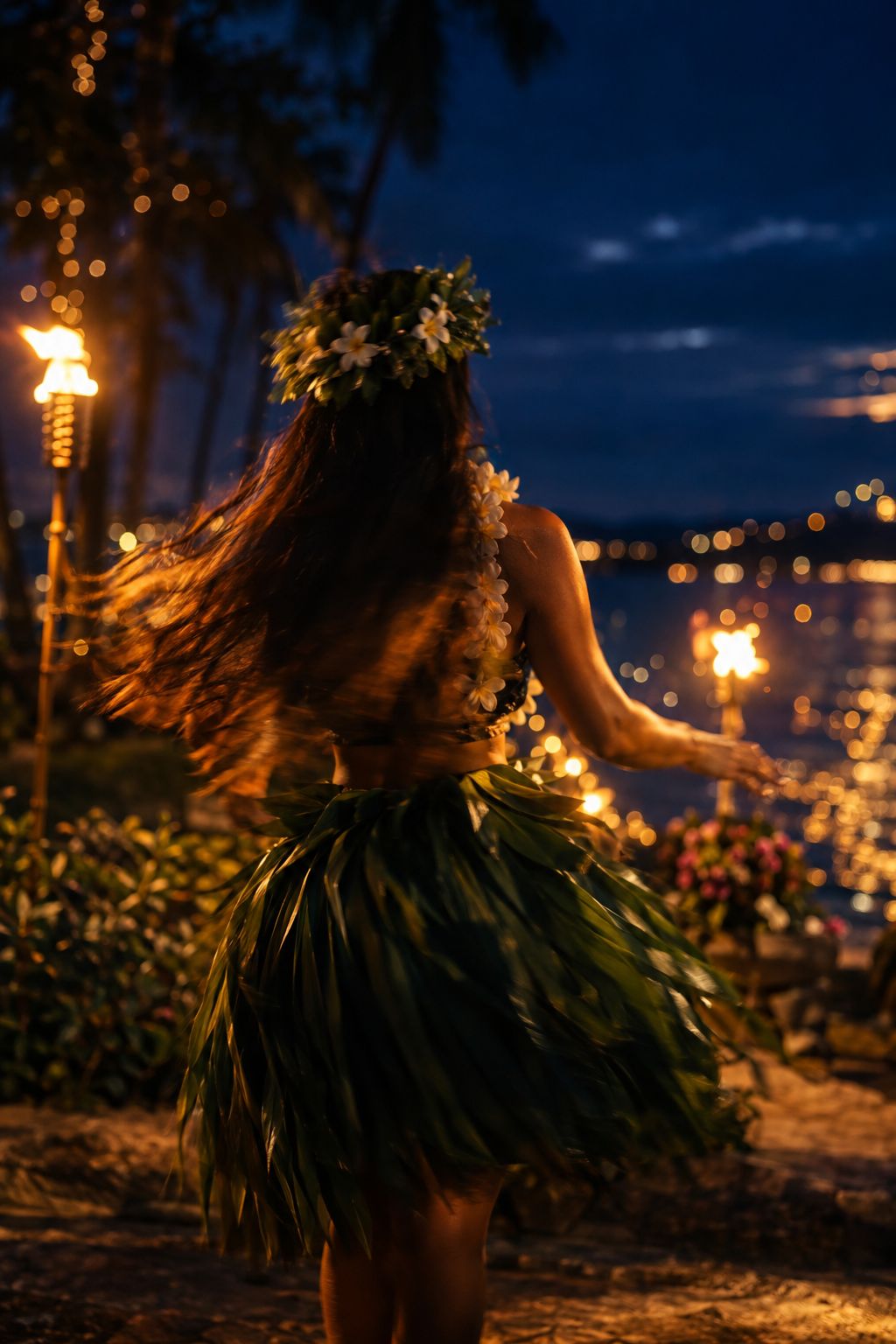 Hula dancer in a tī leaf skirt by torchlight
